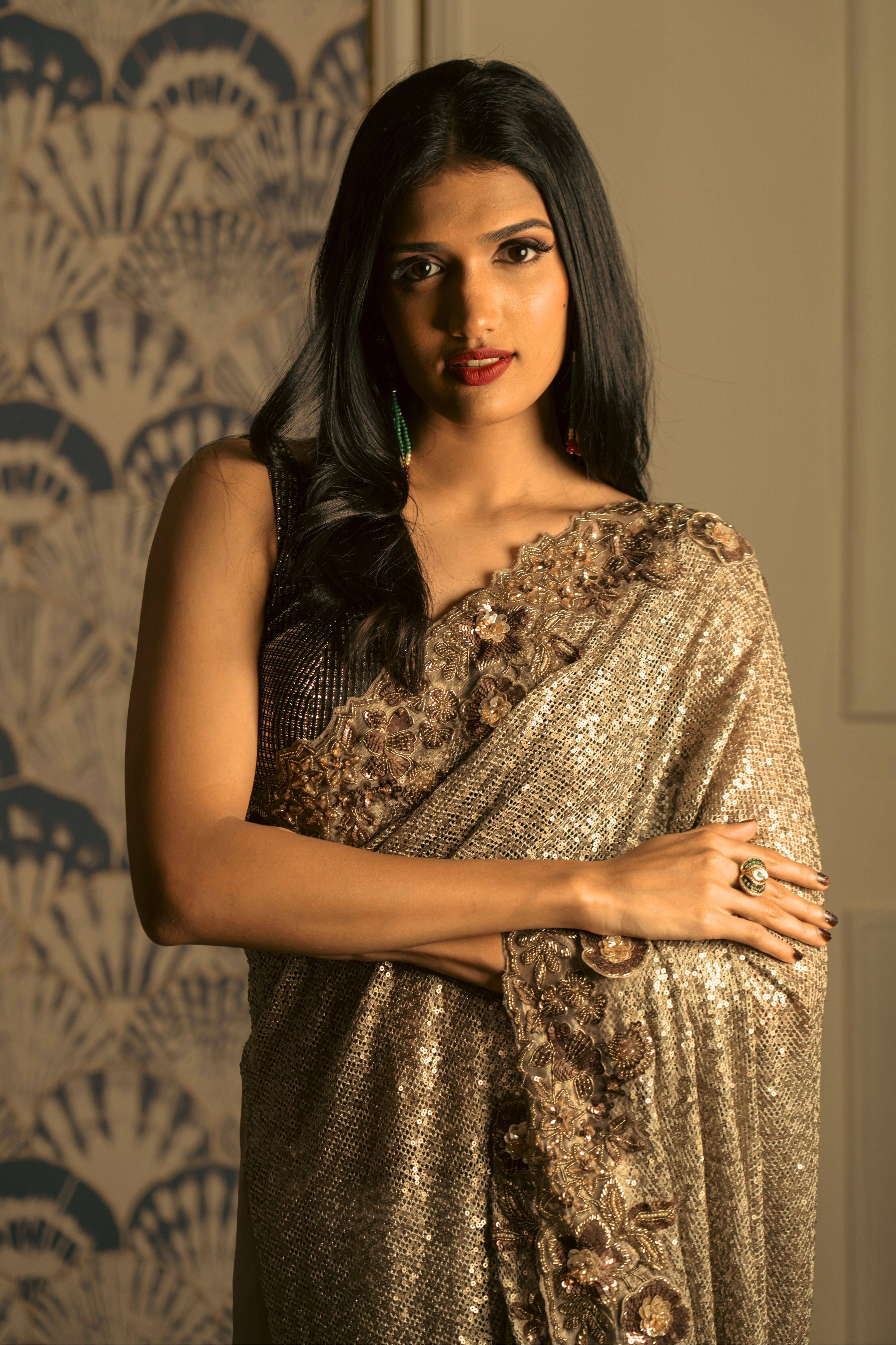 Woman wearing an antique gold sequin saree with handcrafted borders